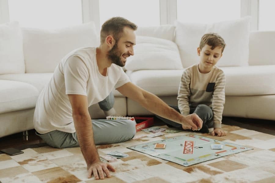 Pai usa banco imobiliário com filho para ensinar planejamento familiar