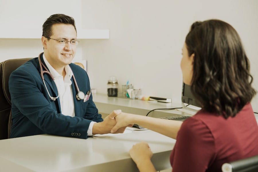 Médico aperta mão de paciente, representando seguro de responsabilidade civil